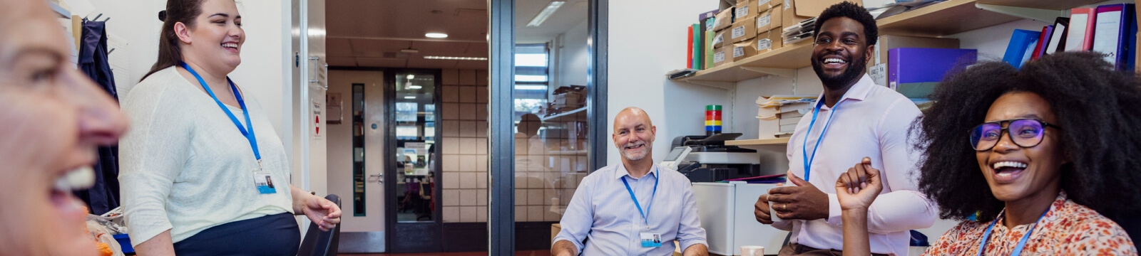 group of teachers laughing together in a break room 