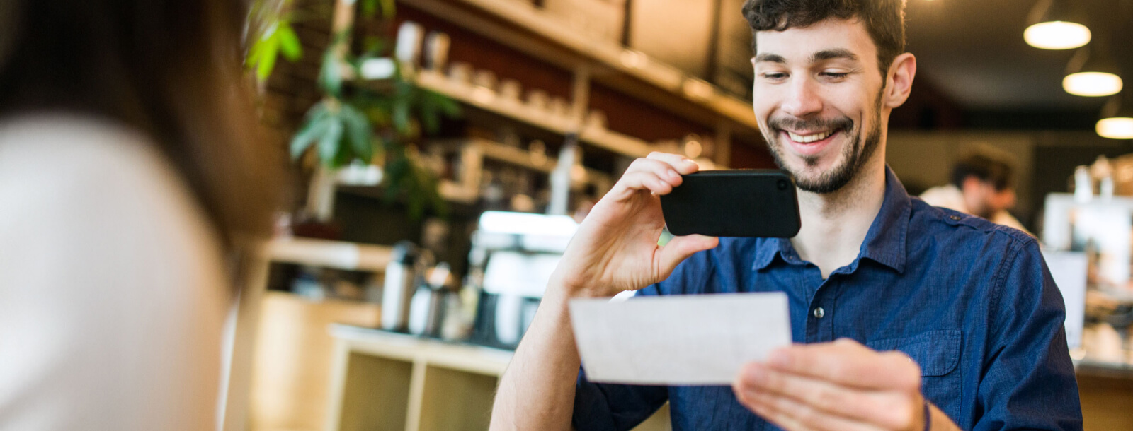 man holding up a smartphone to take a picture of a bank check