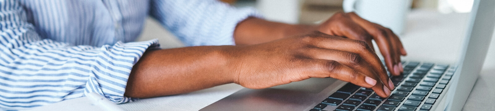 close-up of hands typing on a keyboard