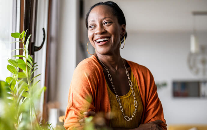 Smiling woman looking out a sunny window